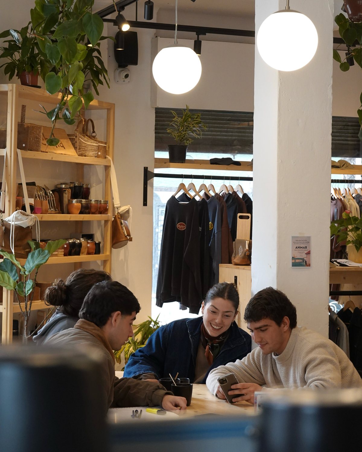 Tres amigos en la mesa comunal de Mirador, con la tienda y los globos de luz atrás